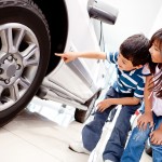 Kids looking at car wheels